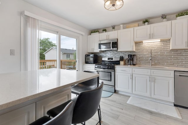 1669 W Bayside Ct, Hoffman Estates, IL 60192 - kitchen with appliances with stainless steel finishes, tasteful backsplash, white cabinets, and light stone countertops