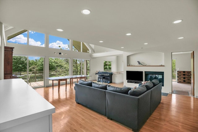 2405 Prairieridge Pl, Champaign, IL 61822 - living room featuring recessed lighting, a glass covered fireplace, healthy amount of natural light, light wood-style flooring, and a high ceiling