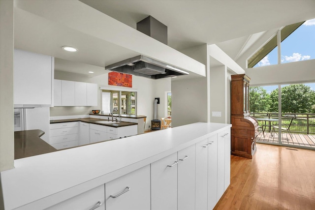 2405 Prairieridge Pl, Champaign, IL 61822 - kitchen featuring a peninsula, white cabinets, light wood-style flooring, wall chimney exhaust hood, and recessed lighting