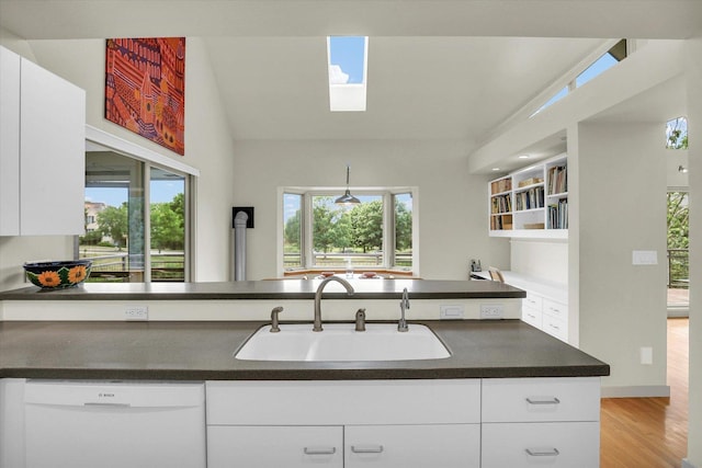 2405 Prairieridge Pl, Champaign, IL 61822 - kitchen featuring dark countertops, white dishwasher, light wood-type flooring, white cabinets, and plenty of natural light