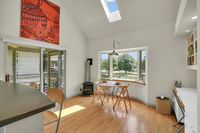 2405 Prairieridge Pl, Champaign, IL 61822 - dining room with a skylight, light wood-type flooring, high vaulted ceiling, and a wood stove