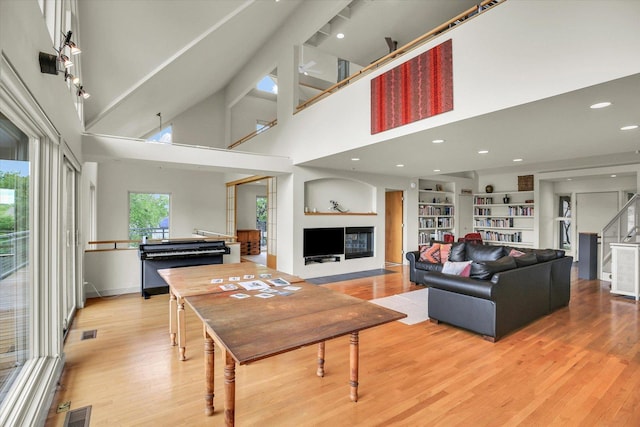 2405 Prairieridge Pl, Champaign, IL 61822 - living room featuring light wood finished floors, a glass covered fireplace, built in shelves, recessed lighting, and a high ceiling