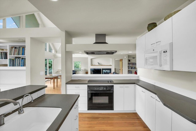 2405 Prairieridge Pl, Champaign, IL 61822 - kitchen with black oven, white microwave, dark countertops, wall chimney exhaust hood, and white cabinetry