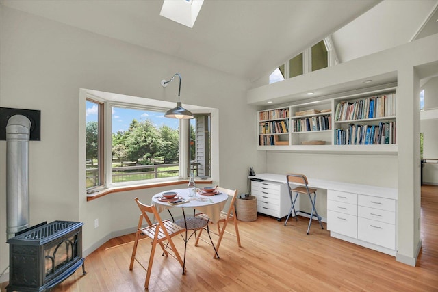 2405 Prairieridge Pl, Champaign, IL 61822 - dining space featuring a wood stove, light wood-type flooring, high vaulted ceiling, a skylight, and built in desk