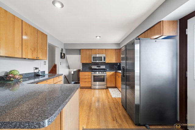 500 S Princeton Ave, Itasca, IL 60143 - kitchen with appliances with stainless steel finishes, light wood finished floors, a peninsula, dark countertops, and decorative backsplash
