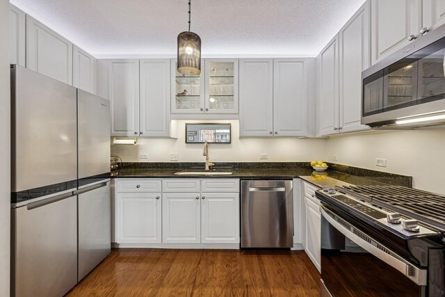 400 Mcdaniels Cir Unit 303, Clarendon Hills, IL 60514 - kitchen featuring appliances with stainless steel finishes, white cabinets, pendant lighting, glass insert cabinets, and dark wood-type flooring