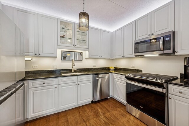 400 Mcdaniels Cir Unit 303, Clarendon Hills, IL 60514 - kitchen featuring stainless steel appliances, dark wood-style flooring, white cabinetry, glass insert cabinets, and hanging light fixtures