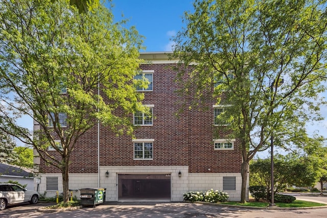 400 Mcdaniels Cir Unit 303, Clarendon Hills, IL 60514 - view of side of property featuring an attached garage, driveway, and brick siding