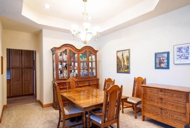 9000 226th Ct Unit 23B, Salem, WI 53168 - dining room featuring a chandelier, light colored carpet, and a tray ceiling