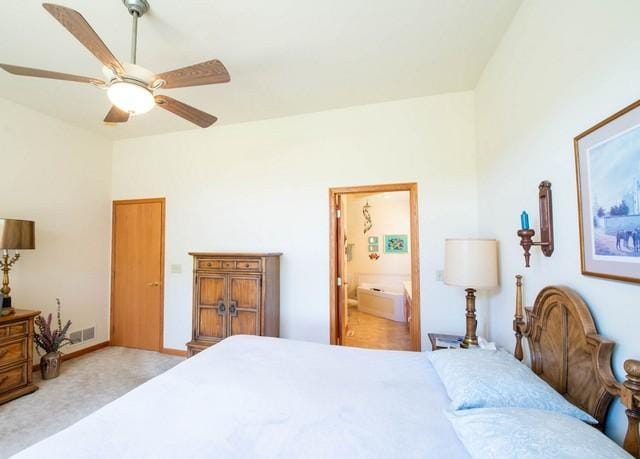 9000 226th Ct Unit 23B, Salem, WI 53168 - bedroom with connected bathroom, carpet, ceiling fan, and vaulted ceiling
