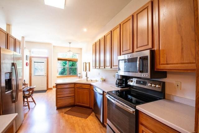9000 226th Ct Unit 23B, Salem, WI 53168 - kitchen with stainless steel appliances, light wood-style floors, and brown cabinets
