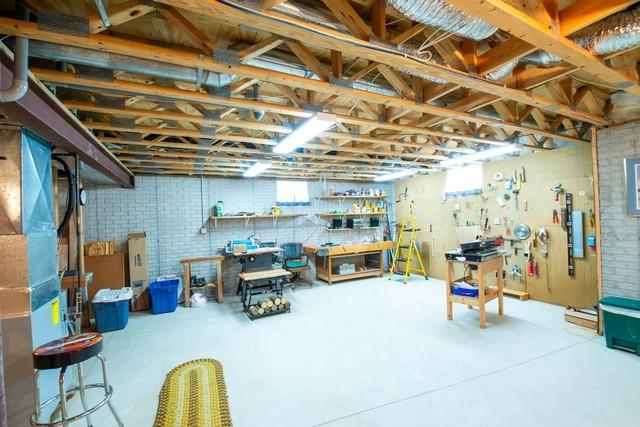 9000 226th Ct Unit 23B, Salem, WI 53168 - basement featuring a workshop area, brick wall, and healthy amount of natural light