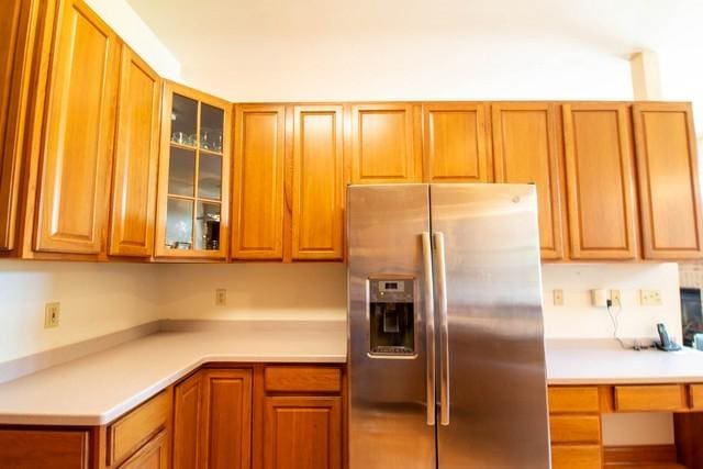 9000 226th Ct Unit 23B, Salem, WI 53168 - kitchen with stainless steel fridge with ice dispenser, glass insert cabinets, light countertops, and brown cabinets