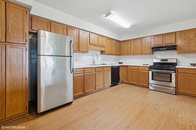 5225 N Riversedge Ter Unit 511, Chicago, IL 60630 - kitchen with appliances with stainless steel finishes, brown cabinetry, under cabinet range hood, and light wood-style flooring