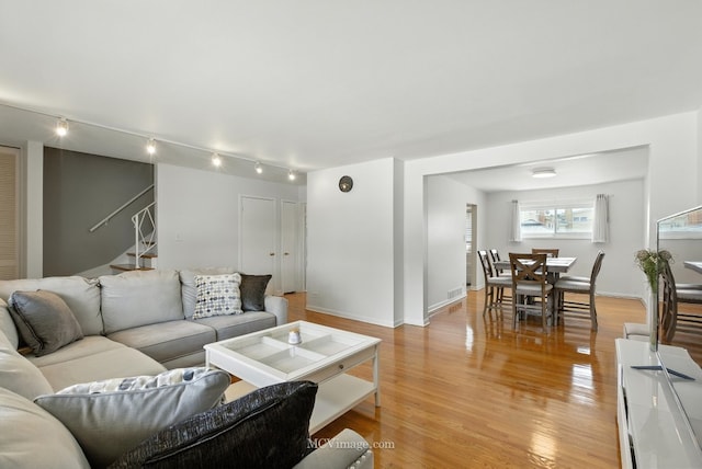 7003 W Carol Ave, Niles, IL 60714 - living room featuring stairway, track lighting, and light wood-type flooring