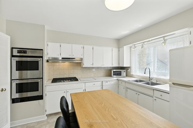 7003 W Carol Ave, Niles, IL 60714 - kitchen featuring white appliances, under cabinet range hood, light countertops, decorative backsplash, and white cabinets