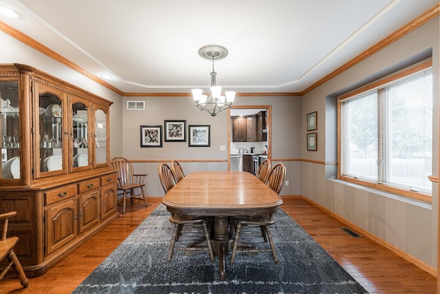 1132 Swanberg Ct, Sycamore, IL 60178 - dining room featuring a chandelier, light wood-style floors, a wainscoted wall, and crown molding