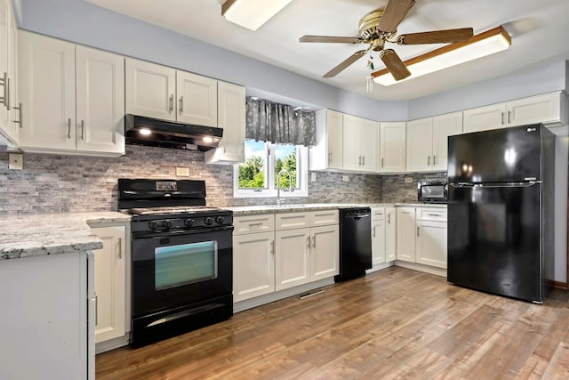 17257 W Rich Ct, Elwood, IL 60421 - kitchen with black appliances, under cabinet range hood, ceiling fan, white cabinets, and decorative backsplash