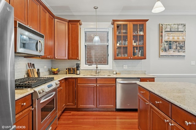 2438 N Clybourn Ave Unit 2, Chicago, IL 60614 - kitchen with appliances with stainless steel finishes, light wood finished floors, light stone countertops, tasteful backsplash, and glass insert cabinets