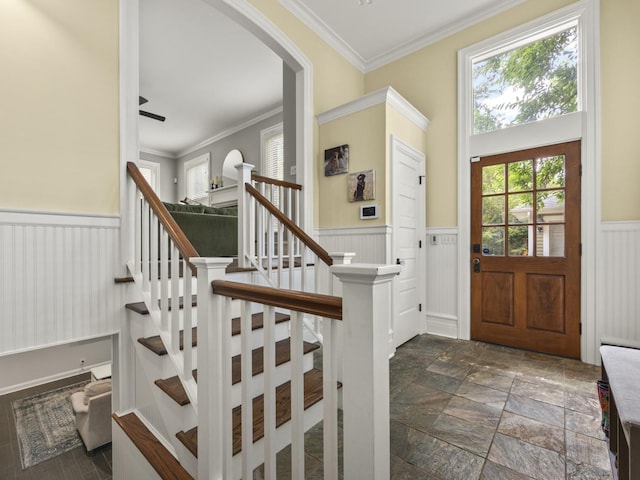 239 7th Ave, La Grange, IL 60525 - foyer featuring arched walkways, a wainscoted wall, ornamental molding, stairs, and stone tile floors