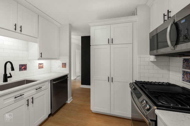 2201 S Stewart Ave Unit 4J, Lombard, IL 60148 - kitchen featuring appliances with stainless steel finishes, white cabinetry, light wood-style flooring, and backsplash