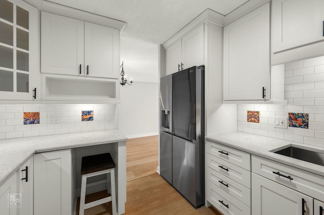 2201 S Stewart Ave Unit 4J, Lombard, IL 60148 - kitchen with stainless steel refrigerator with ice dispenser, decorative backsplash, light wood-style floors, white cabinets, and light stone countertops