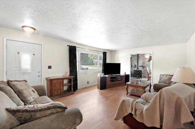 2425 Lockner Blvd, Joliet, IL 60431 - living area featuring a wood stove, a textured ceiling, and light wood finished floors