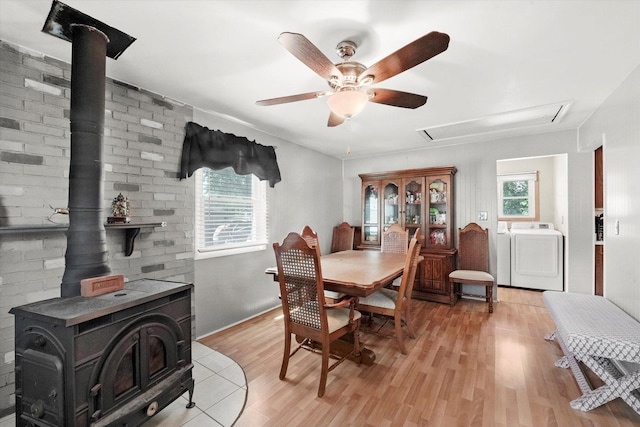 2425 Lockner Blvd, Joliet, IL 60431 - dining area featuring a wood stove, attic access, light wood-style floors, ceiling fan, and washing machine and dryer