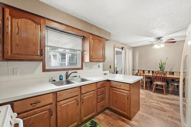 2425 Lockner Blvd, Joliet, IL 60431 - kitchen with a peninsula, stove, light wood-style floors, brown cabinets, and a textured ceiling