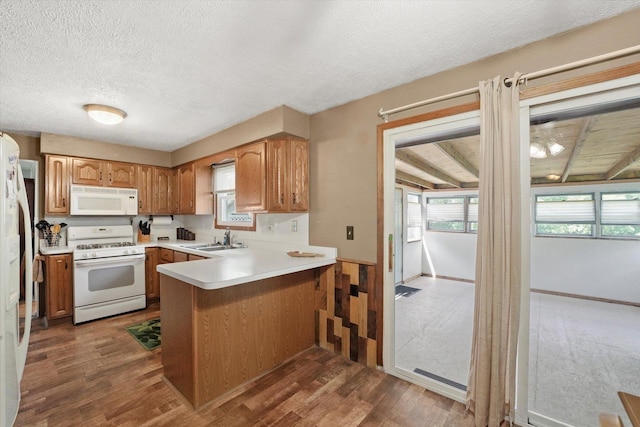 2425 Lockner Blvd, Joliet, IL 60431 - kitchen with white appliances, a peninsula, a textured ceiling, wood finished floors, and light countertops