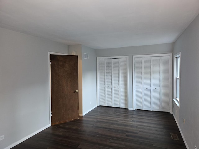 623 Westmoreland Ave, Waukegan, IL 60085 - unfurnished bedroom with multiple closets and dark wood-type flooring
