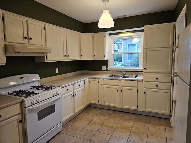 623 Westmoreland Ave, Waukegan, IL 60085 - kitchen featuring white appliances, under cabinet range hood, light tile patterned floors, light countertops, and white cabinetry