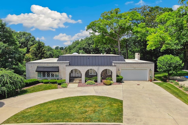 712 Ridge Rd, Lemont, IL 60439 - view of front of home with a front yard, curved driveway, an attached garage, a chimney, and a standing seam roof