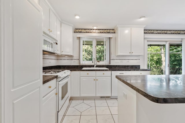 712 Ridge Rd, Lemont, IL 60439 - kitchen with white appliances, dark countertops, tasteful backsplash, light tile patterned flooring, and white cabinets