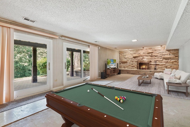 712 Ridge Rd, Lemont, IL 60439 - recreation room featuring pool table, plenty of natural light, a textured ceiling, wooden walls, and a fireplace