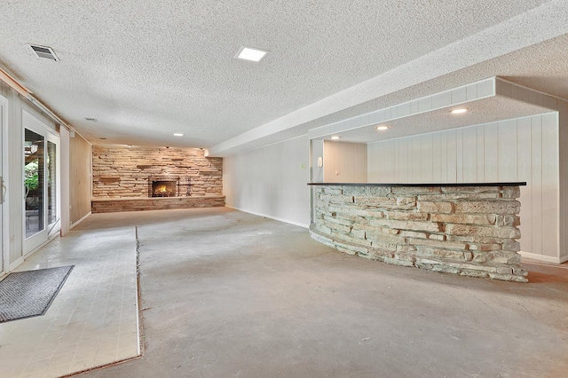 712 Ridge Rd, Lemont, IL 60439 - unfurnished living room featuring a fireplace, a textured ceiling, unfinished concrete floors, recessed lighting, and wood walls