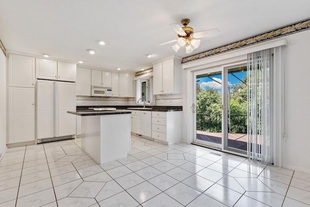 712 Ridge Rd, Lemont, IL 60439 - kitchen featuring white appliances, dark countertops, white cabinetry, light tile patterned floors, and a kitchen island
