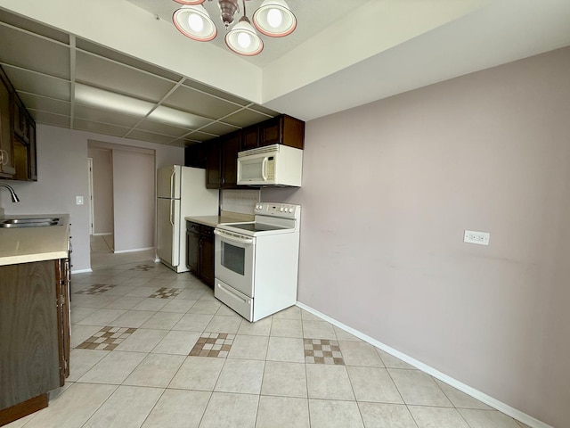 555 Graceland Ave Unit 505, Des Plaines, IL 60016 - kitchen with white appliances, light tile patterned flooring, light countertops, a chandelier, and dark brown cabinets