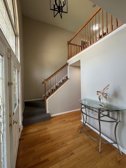 1312 Strawbridge Ct, Naperville, IL 60565 - entryway featuring stairway, wood finished floors, a chandelier, and a towering ceiling