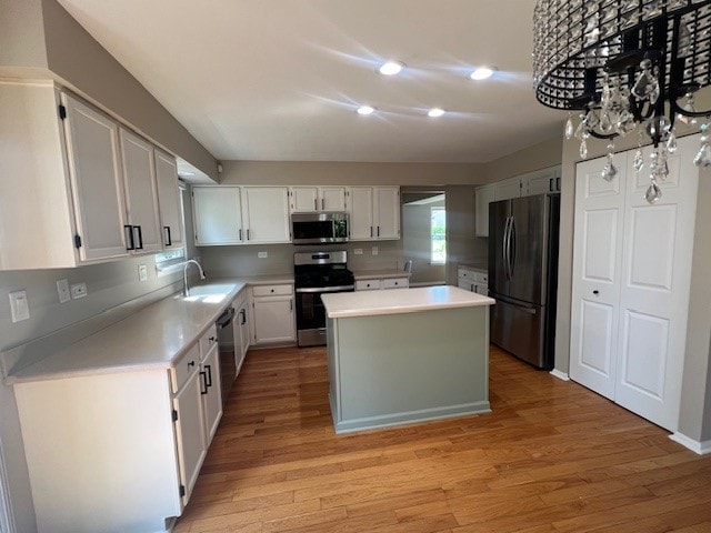 1312 Strawbridge Ct, Naperville, IL 60565 - kitchen featuring stainless steel appliances, a kitchen island, light wood-style floors, light countertops, and white cabinetry