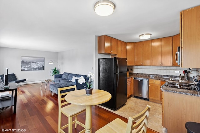 7428 Washington St Unit 508, Forest Park, IL 60130 - kitchen with stainless steel appliances, open floor plan, decorative backsplash, dark stone countertops, and light wood-style floors