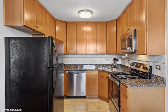 7428 Washington St Unit 508, Forest Park, IL 60130 - kitchen with appliances with stainless steel finishes, tasteful backsplash, light tile patterned floors, dark stone countertops, and brown cabinets