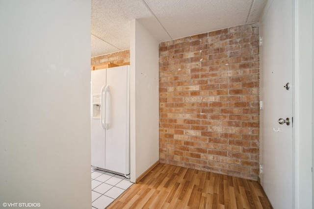 2020 St Johns Ave Unit 309, Highland Park, IL 60035 - empty room with a textured ceiling, brick wall, and light wood-style flooring