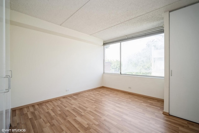 2020 St Johns Ave Unit 309, Highland Park, IL 60035 - unfurnished room with light wood finished floors and a textured ceiling