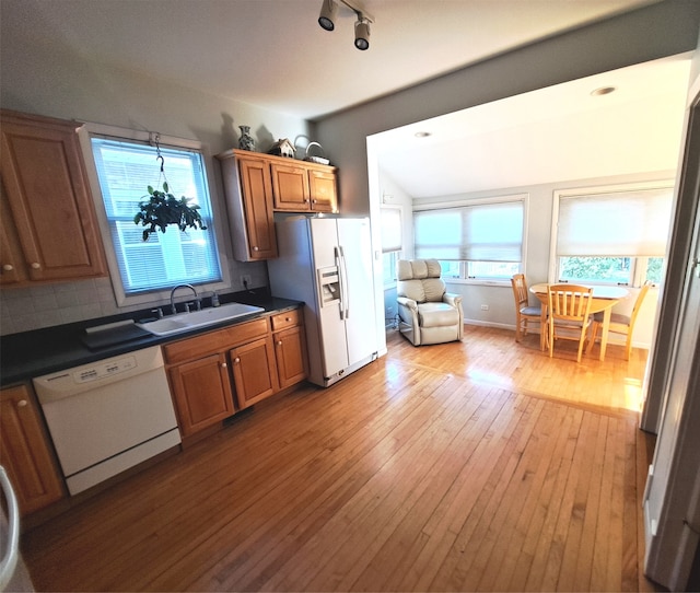 5922 W Dakin St, Chicago, IL 60634 - kitchen featuring white appliances, dark countertops, light wood-style floors, brown cabinets, and decorative backsplash