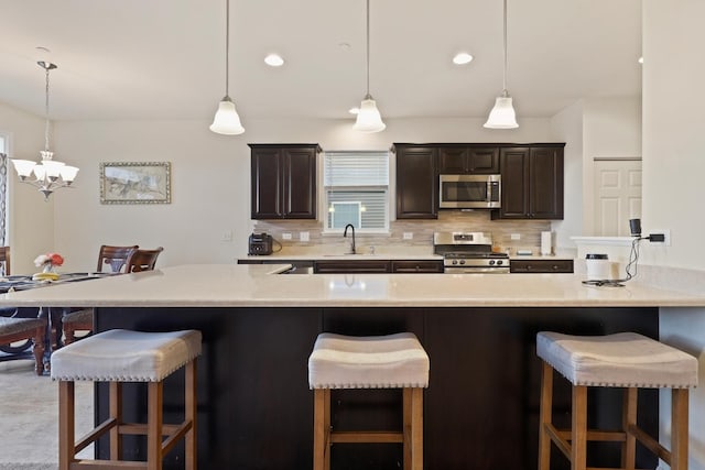 72 Kenneth Ave, Matteson, IL 60443 - kitchen featuring stainless steel appliances, tasteful backsplash, a breakfast bar, and light countertops