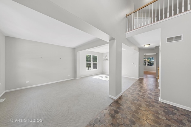 805 W Mystic Ln, Romeoville, IL 60446 - unfurnished living room featuring a chandelier, stone finish floors, and carpet flooring