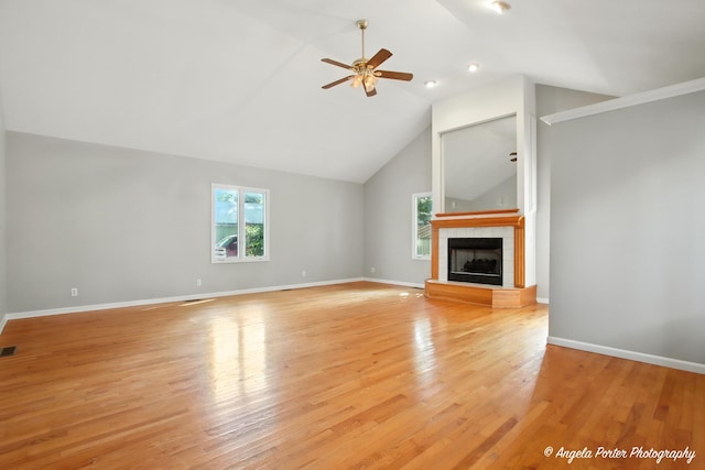 1803 N Woodlawn Park Ave, Mchenry, IL 60051 - unfurnished living room featuring a ceiling fan, light wood-style flooring, a tile fireplace, and high vaulted ceiling