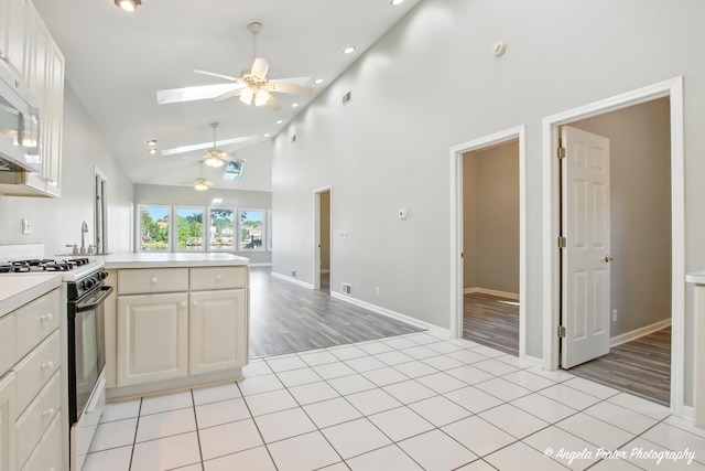 1803 N Woodlawn Park Ave, Mchenry, IL 60051 - kitchen featuring gas range, a ceiling fan, a peninsula, light countertops, and a skylight