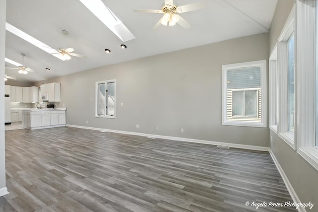 1803 N Woodlawn Park Ave, Mchenry, IL 60051 - unfurnished living room with a skylight, healthy amount of natural light, a ceiling fan, and high vaulted ceiling